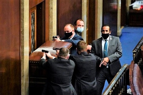 國會警察在國會大廈內拔槍保護國會議員及工作人員進入最近的辦公室避難