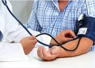 Doctor measuring blood pressure with sphygmomanometer. Image Credit: Kurhan / Shutterstock
